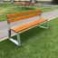 Tallin Bench w/ Backrest, puupenkki metallijalustalla, puistossa.