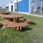 Puiset Round table & benches puistossa rakennuksen vieressä.