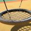 Lintukeinu Bird Nest Swing (BNS 120 cm) hiekkaisella leikkikentällä.