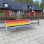 Colourful bench puistossa, sateenkaaren väriset penkin laudat ja metallirunko.