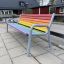 Colourful bench ulkokäyttöön betonilaatoilla, sateenkaaren väreissä, leikkipuistossa.