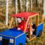 Lapset leikkivät Lava auto -leikkivälineen sisällä ulkona.