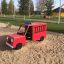 Paloauto-leikkiajoneuvo hiekkalaatikolla leikkipuistossa.