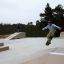 Nuori skeittaaja tekee temppuja Kulmaramppi-skateparkissa.