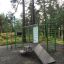 Vihreä Information Board NAF leikkikenttäväline ulkona metsässä.